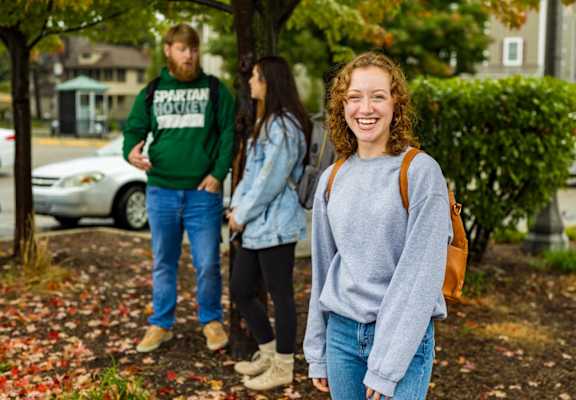 three people walking down a sidewalk near a playground