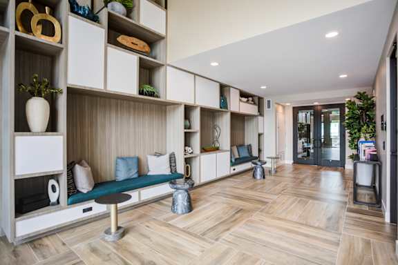 A modern interior with wooden floors and shelves filled with decorative items at Pradera Apartments, San Ramon, California