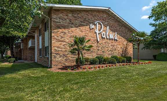 a brick building with a palm tree in front of it