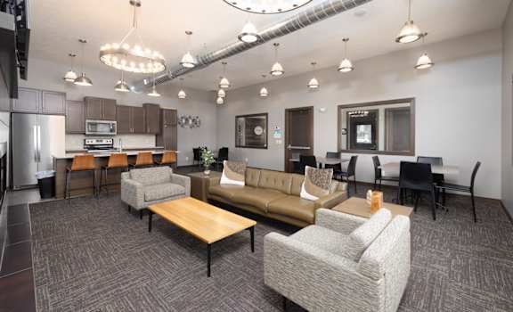 A modern living room with a kitchen area in the background.