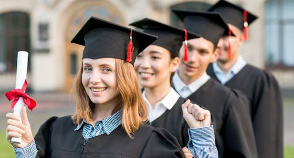 a group of students in graduation gowns standing in a line