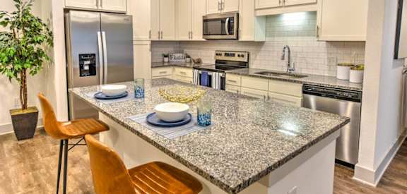 a kitchen with white cabinets and a granite counter top at Fountainhead, Jacksonville, Florida
