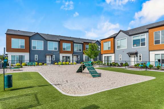 A playground area in front of a row of townhouses.