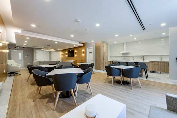 A modern dining room with a long table and chairs.