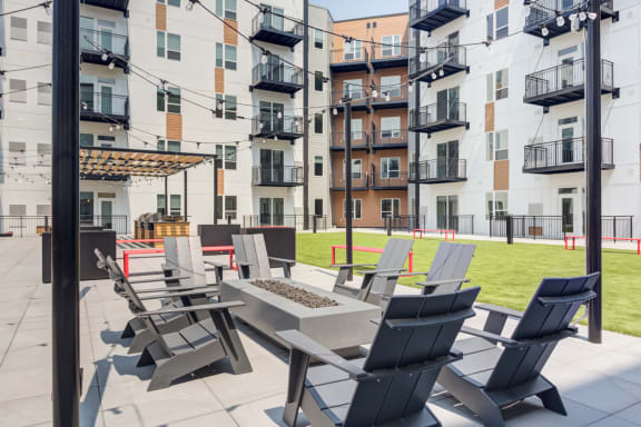 a patio with chairs and a firepit at the bradley braddock road station apartments