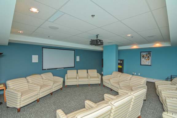 A room with a white ceiling and a screen on the wall.