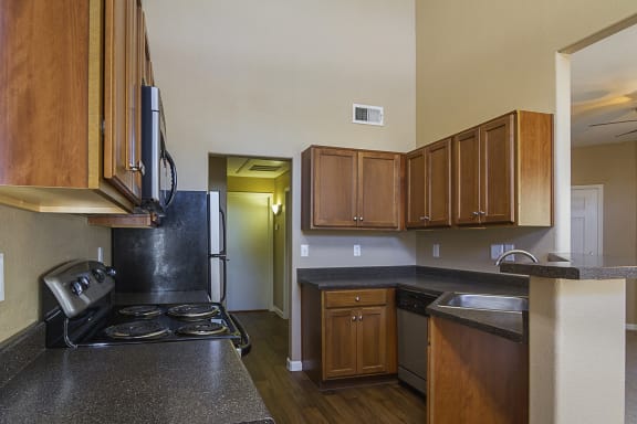 Kitchen with black laminate countertops and walnut stained flat panel cabinet fronts