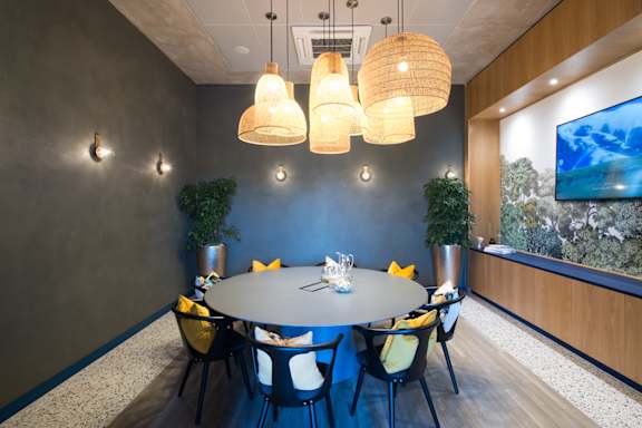 A conference room with a round table and chairs.