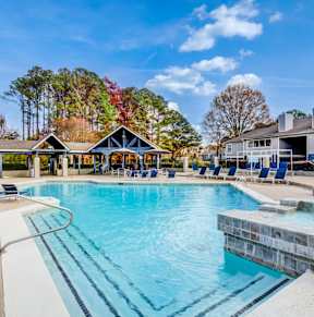 A large swimming pool with a waterfall in the middle of it at Southland Station Apartments, Warner Robins, GA
