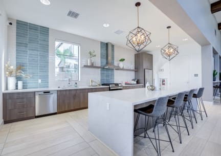 a large white kitchen with a long island with chairs