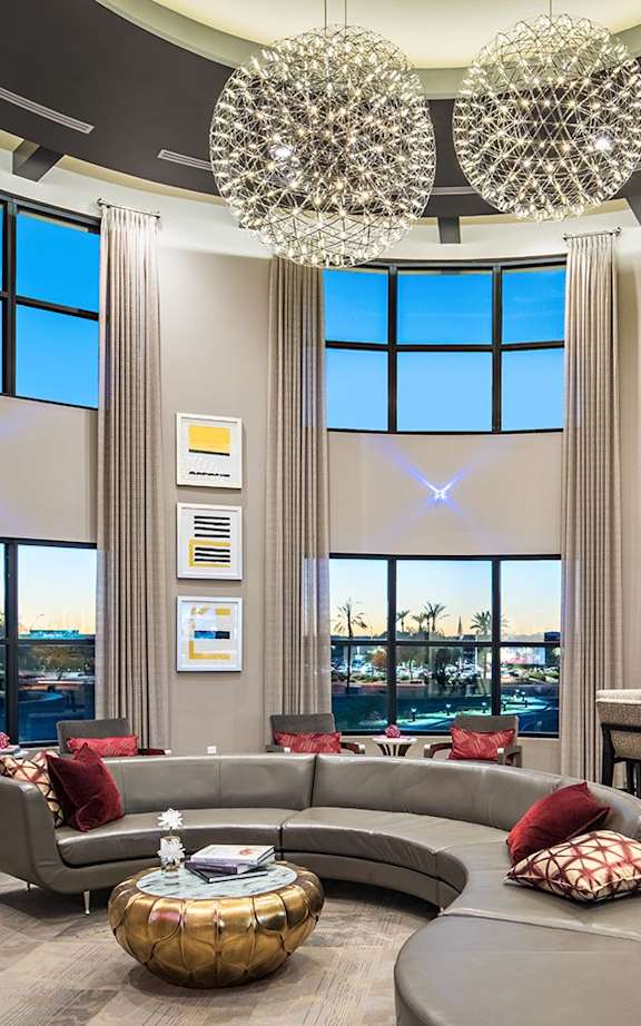 A living room with a blue couch and orange pillows.