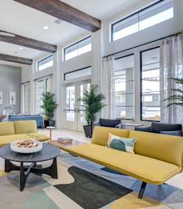 a living room with yellow couches and chairs and a table