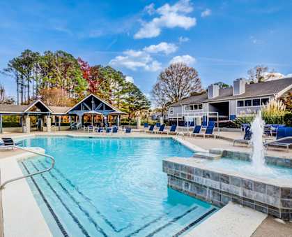 A large swimming pool with a fountain in the middle of it.
