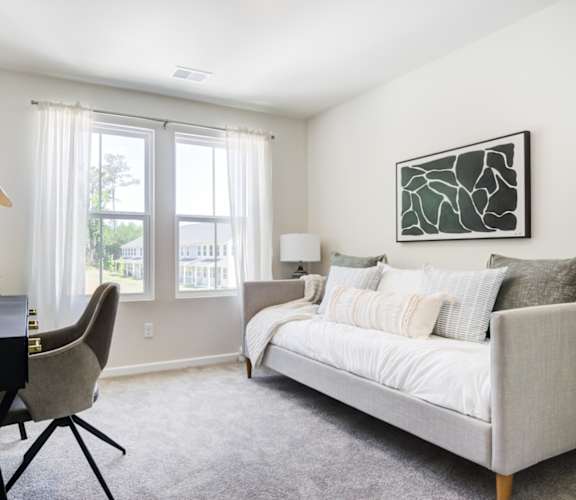 a bedroom with a bed and a desk with a chair
