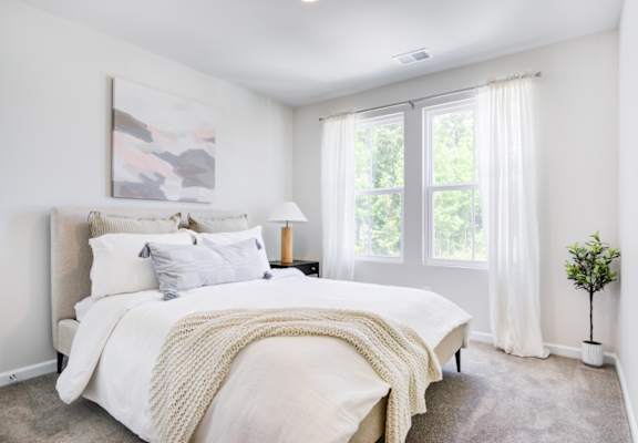 a bedroom with a bed and two windows