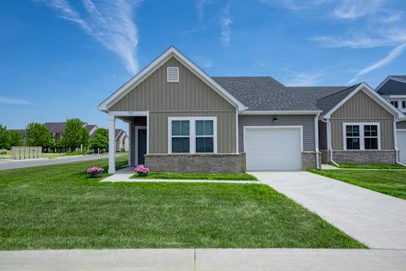 A house with a grey roof and a white garage door.