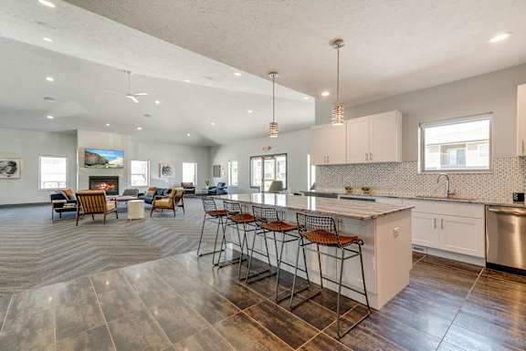 a kitchen and living room with an island and bar stools