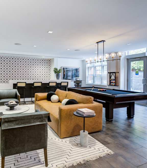 A living room with a pool table and a television.