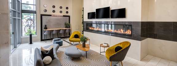 A modern living room with a fireplace and a yellow chair.