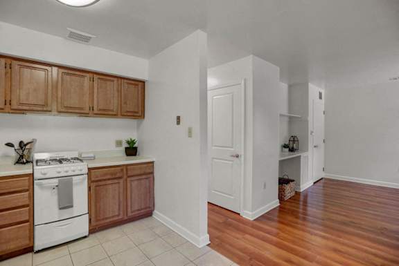 an empty kitchen with wood flooring and white appliances