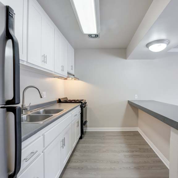 a kitchen with white cabinets and stainless steel appliances
