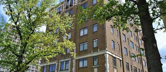 a tall brick building with trees in front of it