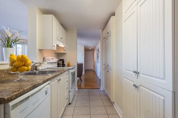 a kitchen with white cabinets and a sink and a counter
