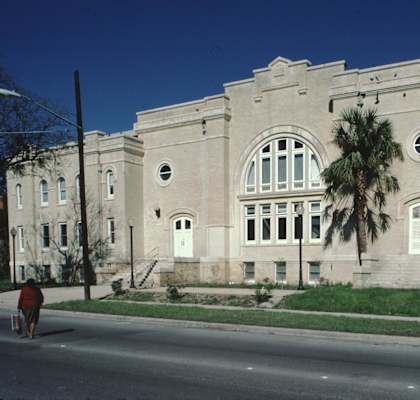 A large building with a palm tree in front of it.