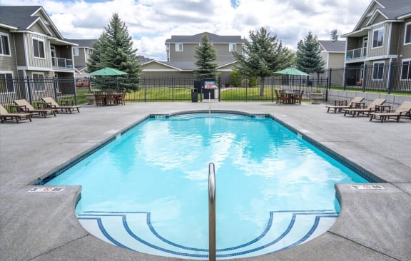 our apartments have a resort style pool with chairs and tables
