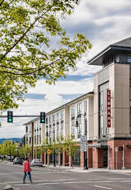 A street view of a building with a pedestrian crossing the road.