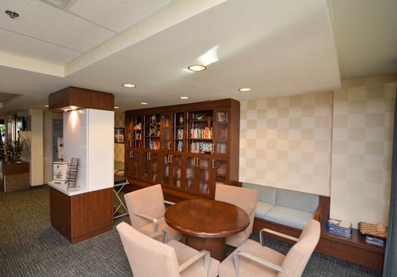 A room with a table, chairs, and a bookshelf.