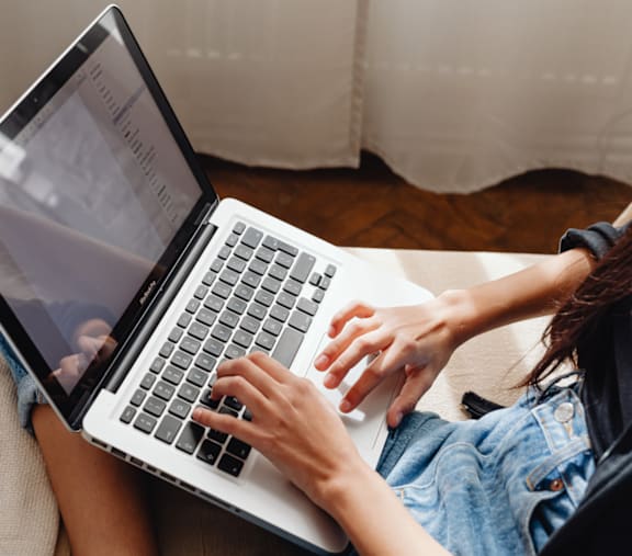 A person is typing on a laptop with a webpage open.