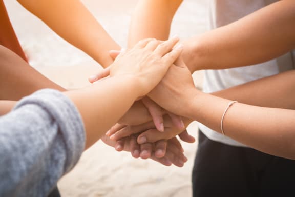 A group of people stacking their hands together.