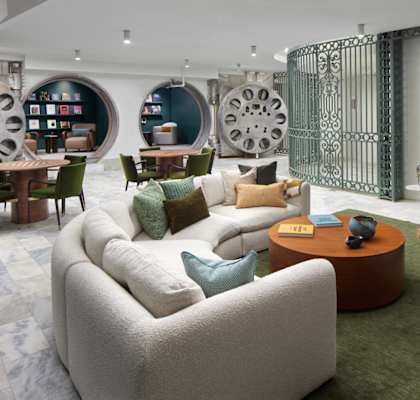 A living room with a white sofa and a green rug.