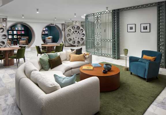 A living room with a white sofa and a green rug.