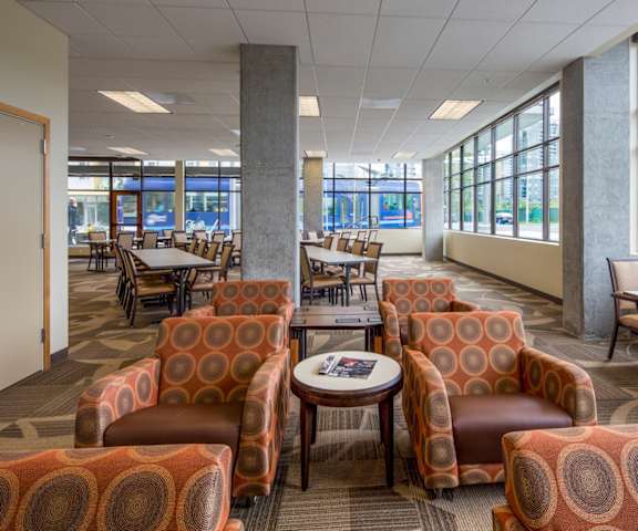 A room with orange chairs and a coffee table.