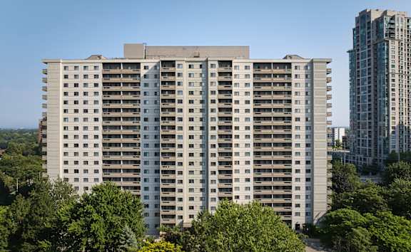 A large building with a lot of windows is surrounded by trees.