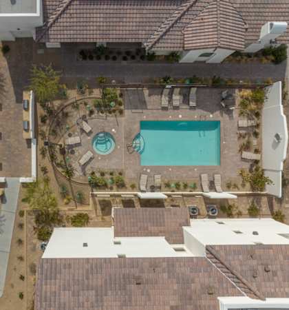 A swimming pool is surrounded by lounge chairs and umbrellas.