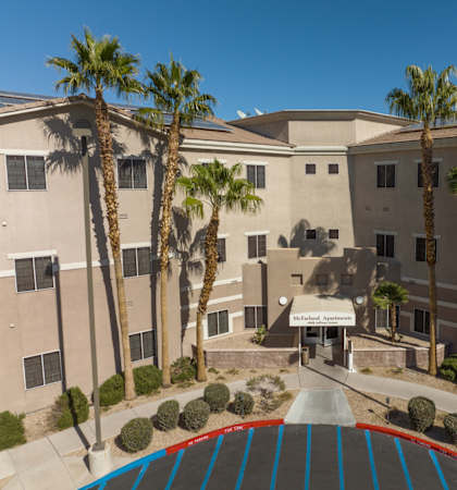 A building with palm trees in front of it.