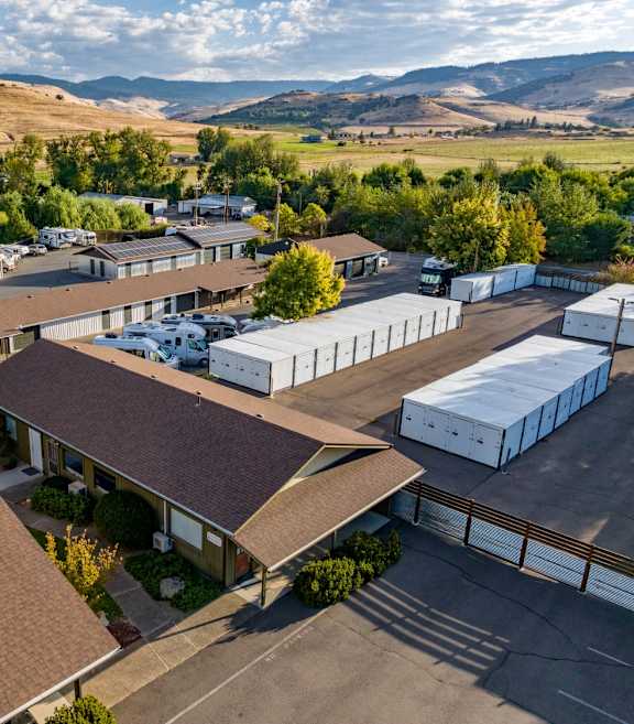 A large building with a brown roof is surrounded by a parking lot.