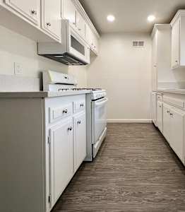 A modern kitchen with white appliances and cabinets.