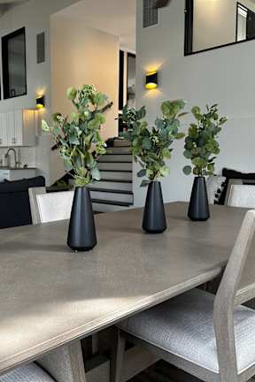 a dining room with a table and chairs and vases