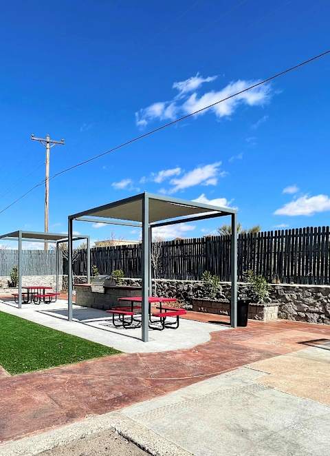 A picnic area with a table and chairs under a shelter.