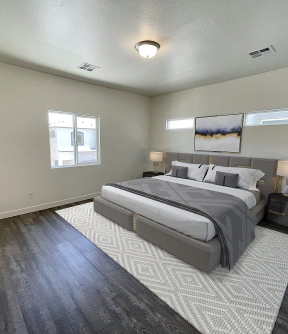 the master bedroom has a king size bed and hardwood floors