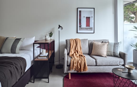 a living room with a green couch and a balcony