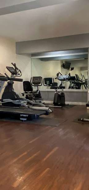 A gym with a treadmill, exercise ball, and other equipment.
