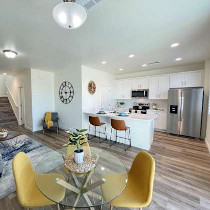 a living room and kitchen with a table and chairs