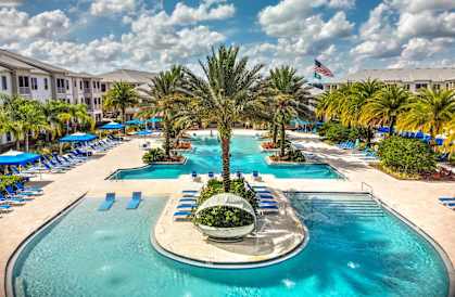 a large swimming pool with a fountain and palm trees at Palm Bay Club, Jacksonville, FL, 32258