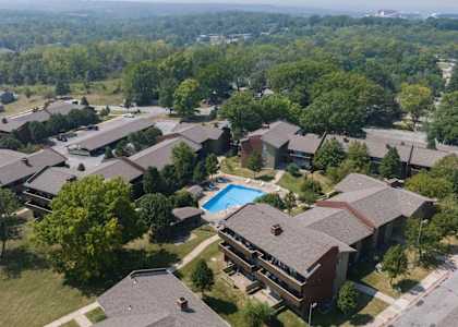 A bird's eye view of a residential area with houses and a swimming pool.