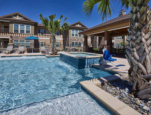 A person is sitting on a blue chair by a pool.